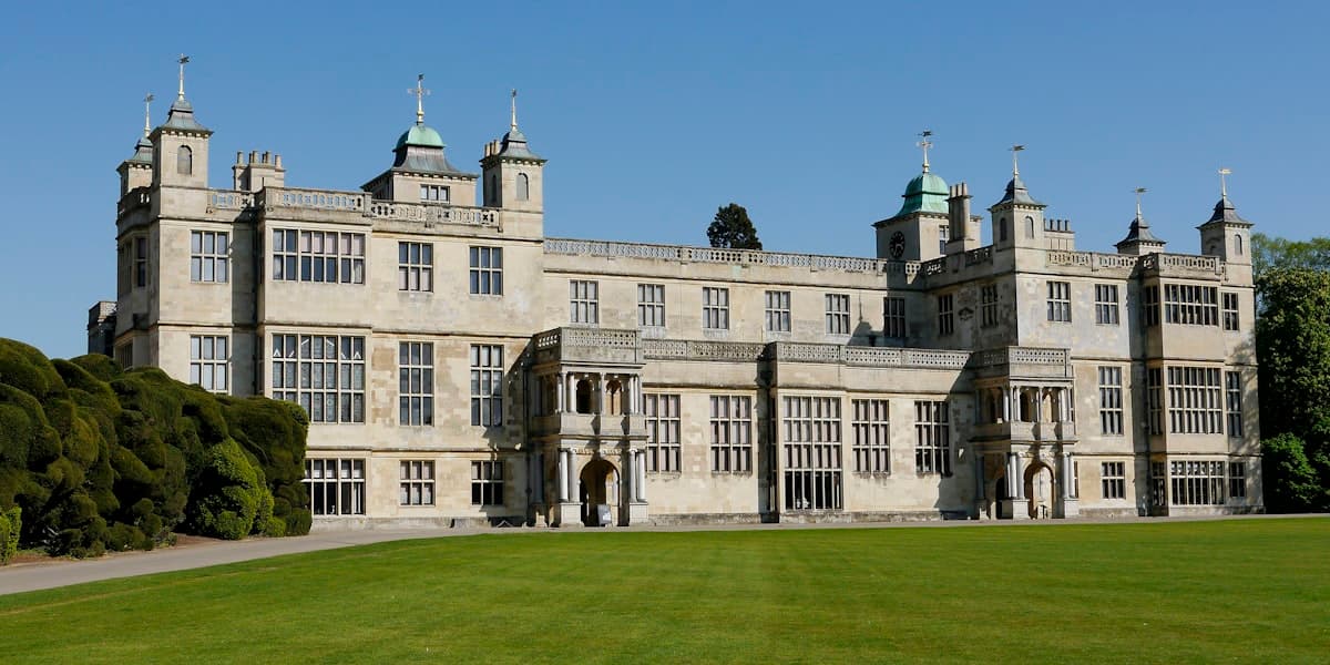 Audley End House, a grand 17th-century English country estate, on a manicured green lawn under a clear sky
